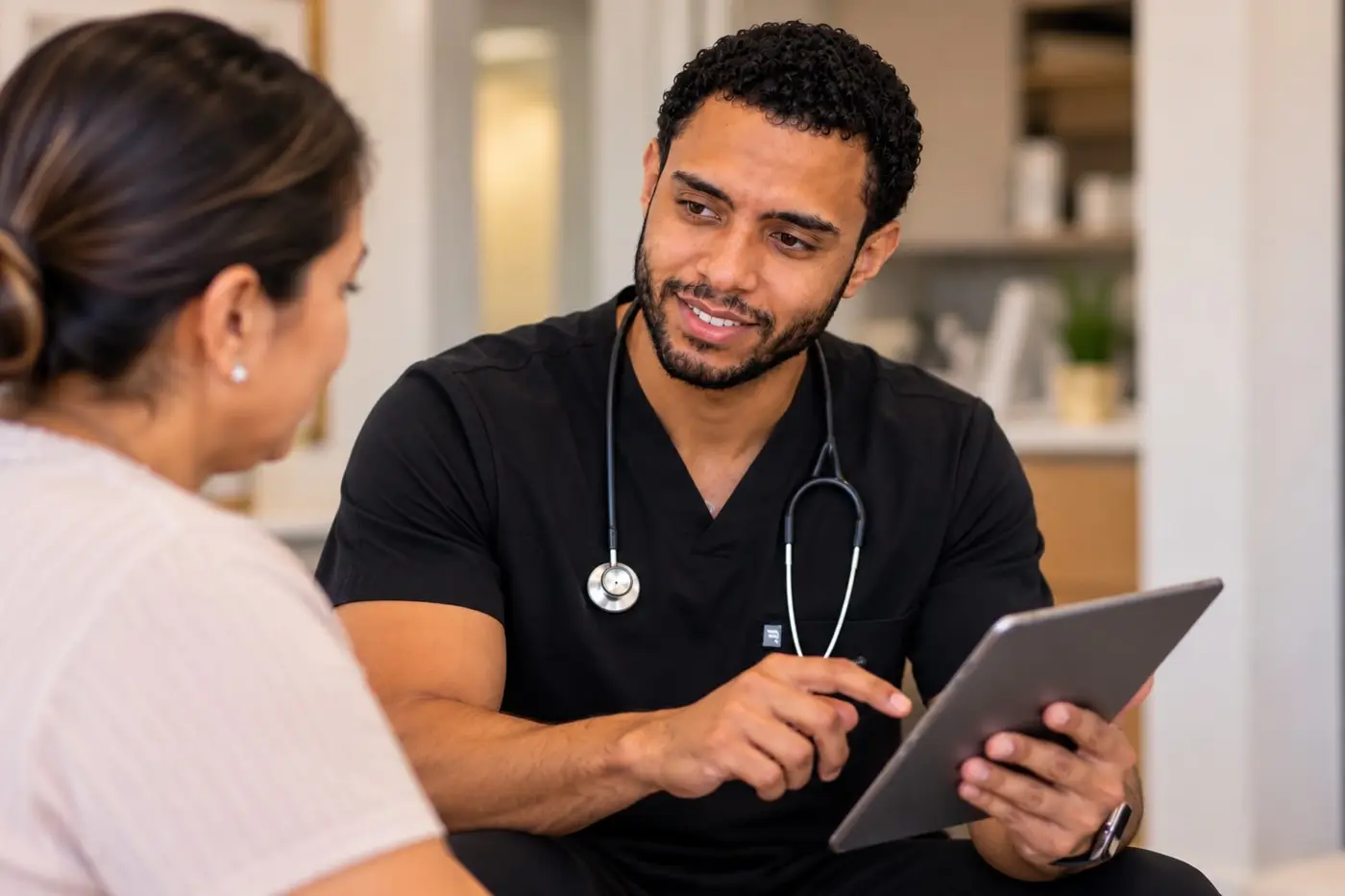 Carlos reviewing information with a patient on a tablet